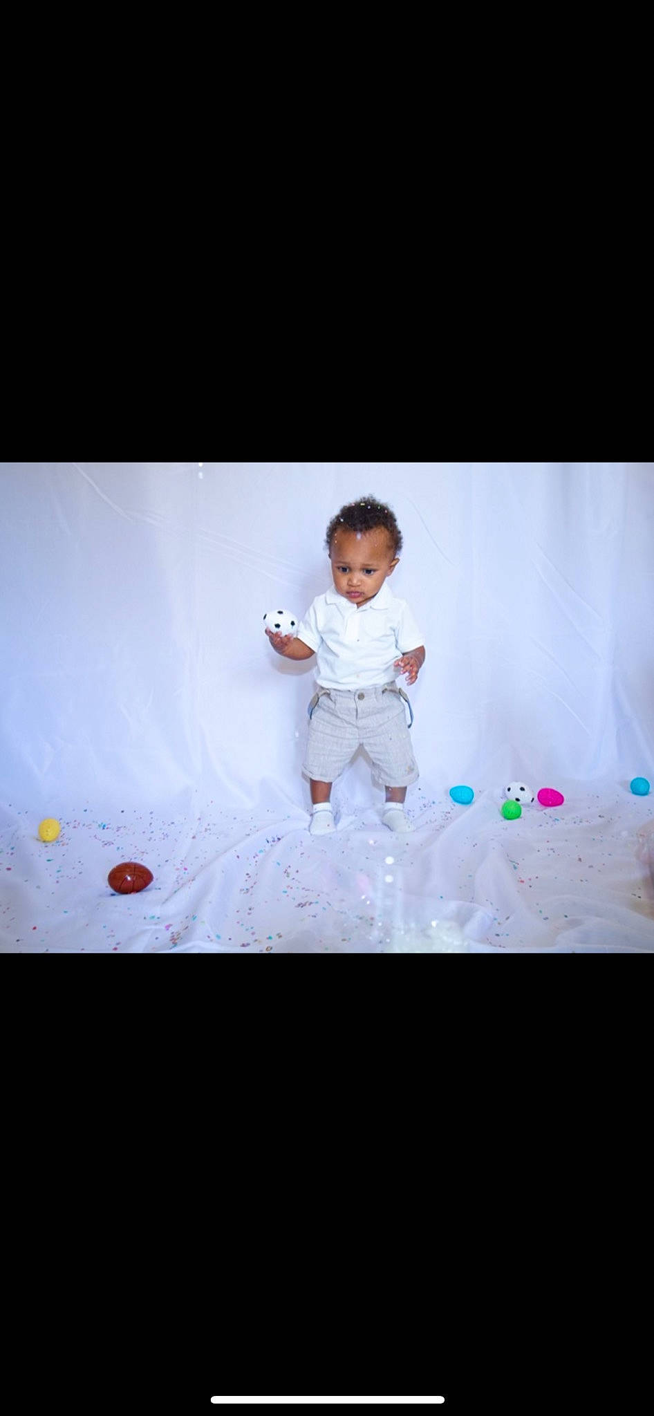 Dontez is registered to the contest to win money with this photo: baby, baby_toddler_clothing, child, flash_photography, flooring, font, fun, gadget, gesture, happy, leisure, magenta, pattern, performing_arts, person, portrait_photography, room, sitting, sleeve, t_shirt