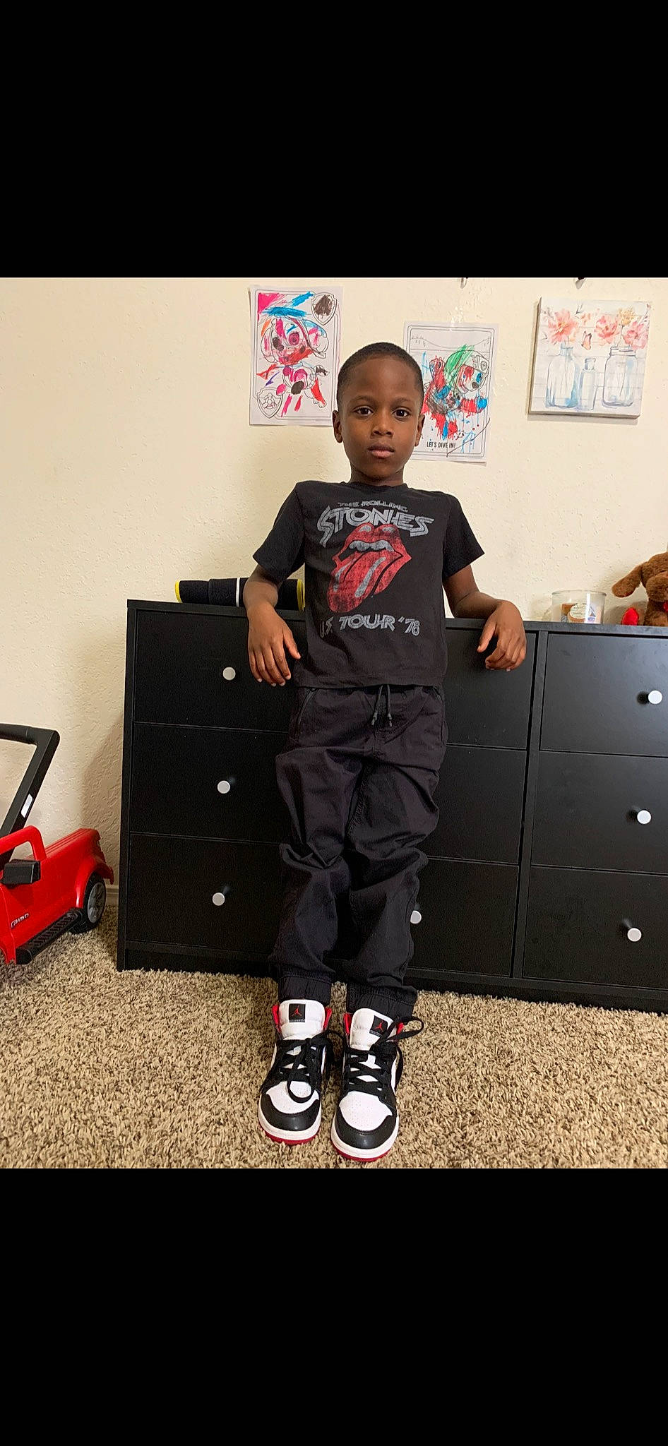 Devon is registered to the contest to win money with this photo: audio_equipment, bag, baggage, boot, cabinetry, chest_of_drawers, drawer, electronic_device, flooring, gadget, happy, knee, luggage_and_bags, person, shoe, sleeve, sneakers, sportswear, t_shirt, thigh