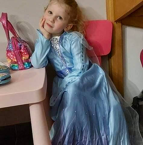 Ema a rejoint le concours — aidez-le/la à gagner de superbes lots ! blond, brown_hair, child, day_dress, dress, embellishment, event, face, fashion_accessory, fashion_design, formal_wear, gown, happy, head, long_hair, person, shoulder, sleeve, smile, table