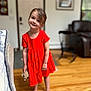 Madison is registered to the contest to win money with this photo: child, girl, red_dress, smile, barefoot, stuffed_animal, toy, wooden_floor, indoor, living_room, furniture, door, picture_frame, happy, person, portrait, head_tilt, cute, young, home
