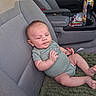baby, infant, child, car, car_seat, vehicle_interior, onesie, blanket, sitting, lying_down, face, portrait, eyes, smiling, relaxed, snacks, cup_holder, fabric, indoor, road_trip