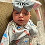 baby, child, headband, bow, clothing, onesie, milk_carton, bacon, croissant, colorful, pattern, face, portrait, indoor, seated, curious, soft_lighting, chair, blurred_background, cute