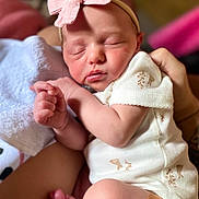 Mckenna joined the competition — help win amazing prizes! newborn, baby, sleeping, headband, bow, onesie, infant, person, hand, foot, skin, cute, peaceful, soft, closeup, resting, human, child, toddler, adorable