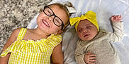 Mckenna joined the competition — help win amazing prizes! child, baby, glasses, yellow_dress, headband, sleeping, smiling, happy, infant, toddler, lying_down, carpet, blanket, indoor, cute, family, portrait, clothing, people, relaxing