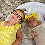 child, baby, glasses, yellow_dress, headband, sleeping, smiling, happy, infant, toddler, lying_down, carpet, blanket, indoor, cute, family, portrait, clothing, people, relaxing