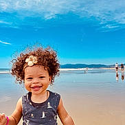 Aracely joined the competition — help win amazing prizes! beach, child, clouds, curly_hair, happy, headband, mountains, ocean, outdoor, person, reflection, sand, seashells, sky, smiling, summer, sunny, toddler, vacation, water