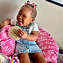 baby, child, girl, smiling, denim_dress, pink_bows, cushion, personalized_blanket, toy, unicorn, wooden_sign, eight_months, sitting, happy, indoors, bracelet, white_shirt, cozy, portrait, cute