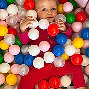 Lana participe au concours pour gagner de l'argent avec cette photo : ball_pit, bright_colors, child, close_up, colorful_balls, cute, face, fun, hand, happy, indoors, legs, plastic_balls, playful, playtime, portrait, red_clothing, smiling, toddler, toy