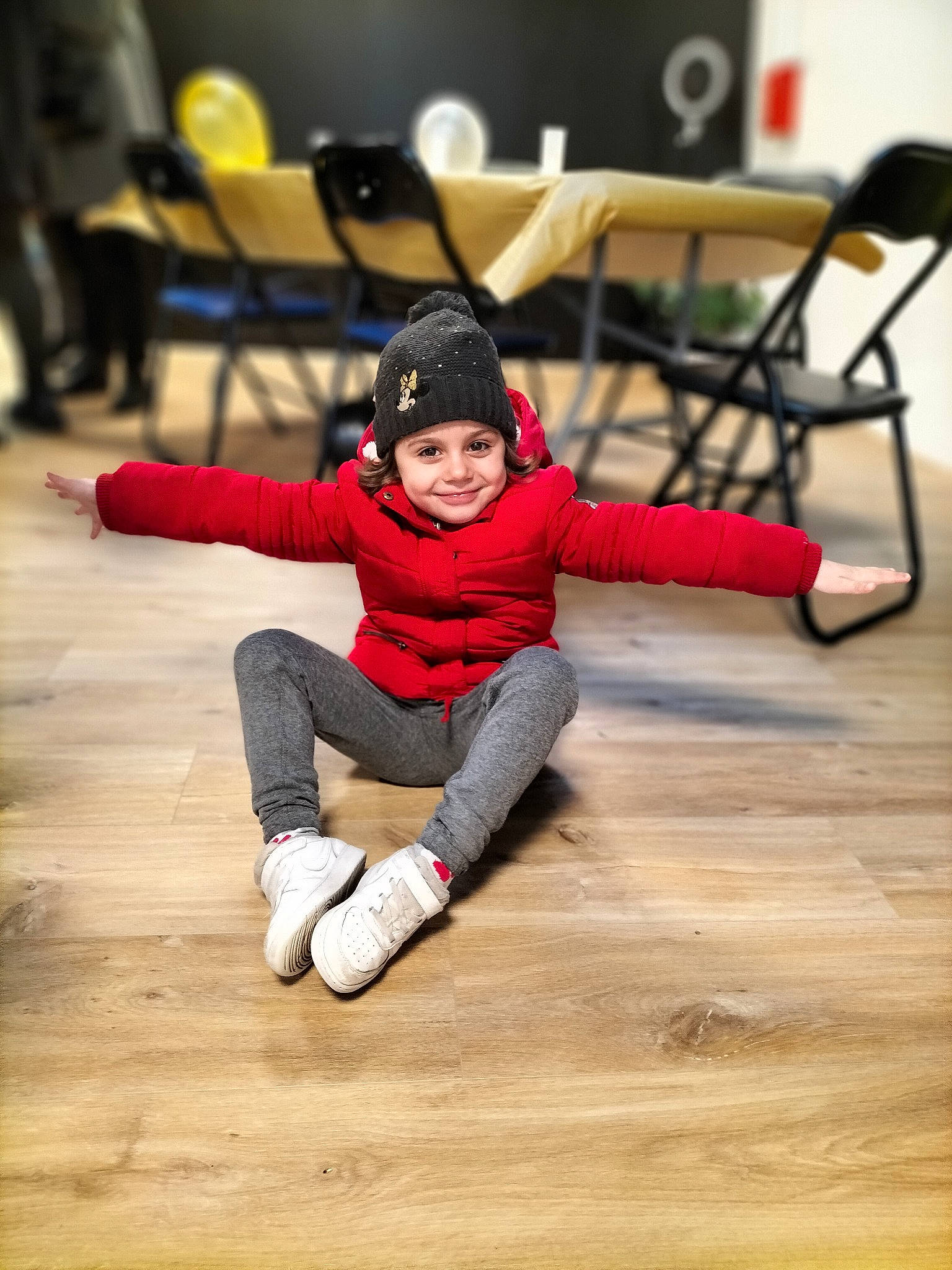 Zoe participe au concours pour gagner de l'argent avec cette photo : chair, floor, flooring, fun, glove, happy, hardwood, headwear, hoodie, joy, knee, laminate_flooring, leisure, person, sitting, smile, sock, sportswear, toddler, winter