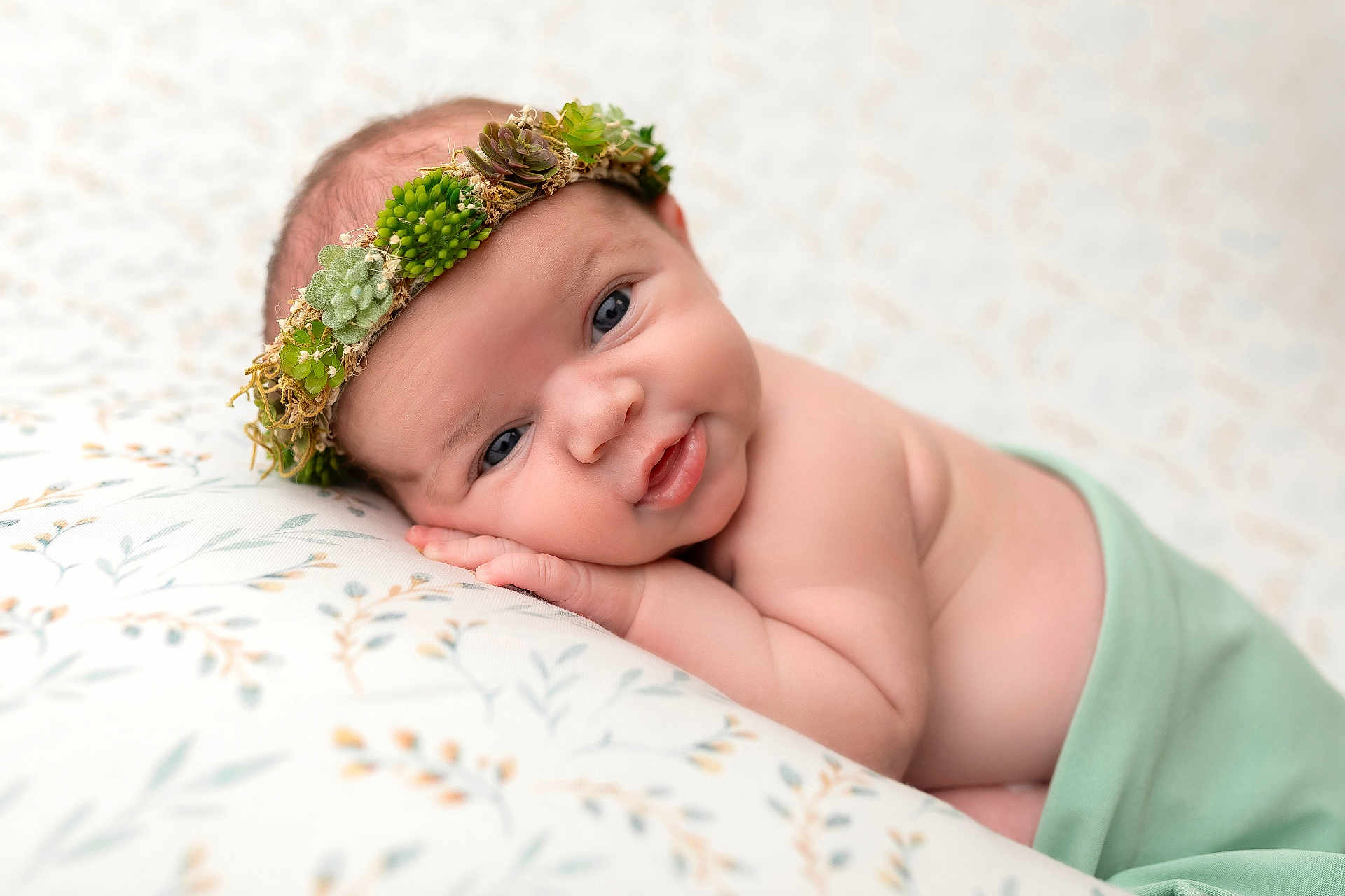 Fern joined the competition — help win amazing prizes! baby, blanket, child, closeup, crown, cute, expression, face, green_cloth, hand, headwear, indoors, infant, lying_down, newborn, pattern, portrait, skin, soft_light, succulent