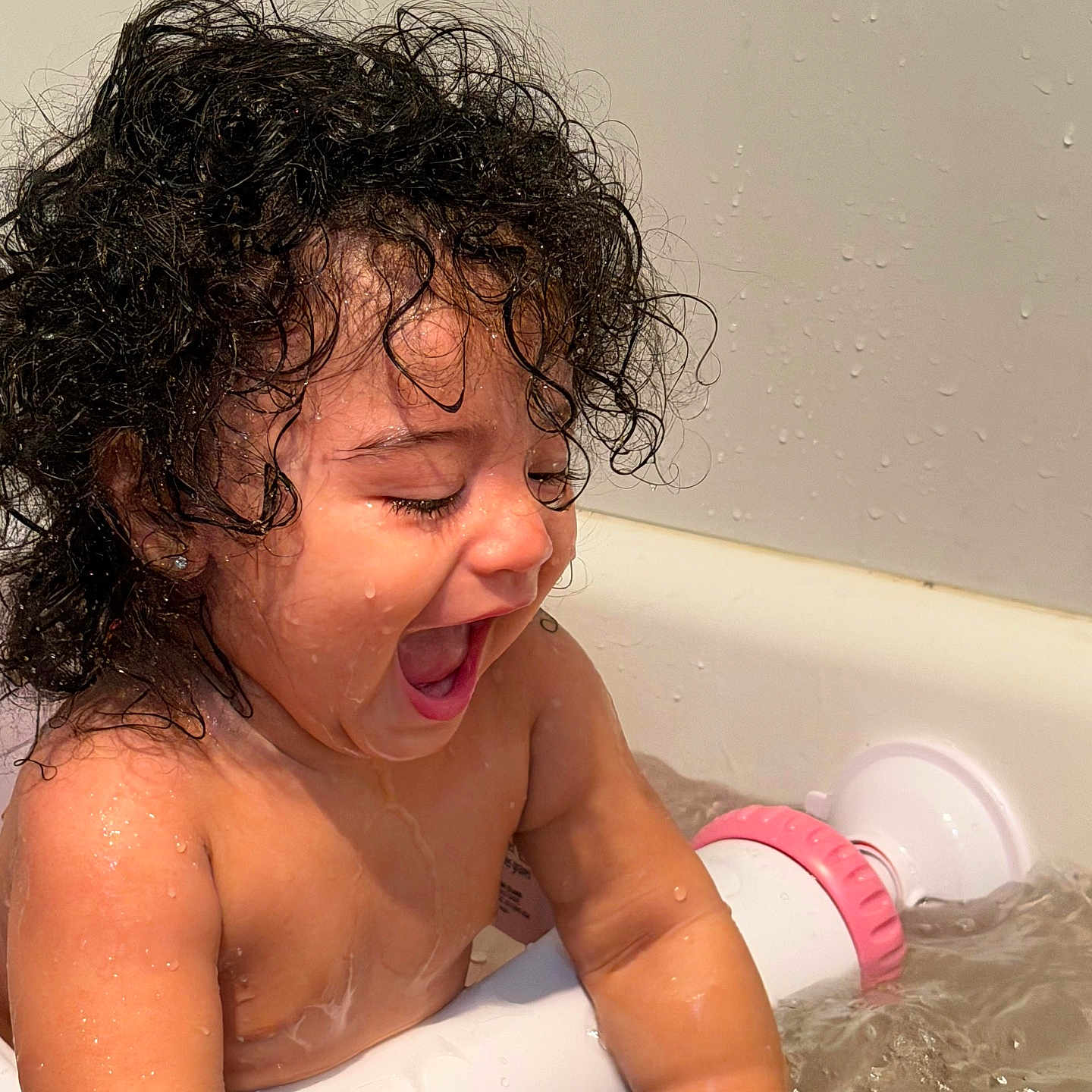 Elianne is registered to the contest to win money with this photo: toddler, child, bath, water, curly_hair, wet, happy, smiling, playing, bathtub, skin, splashing, fun, indoor, person, cute, joyful, young_child, bath_toy, closeup