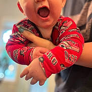 Chase joined the competition — help win amazing prizes! baby, child, infant, red_clothing, hand, face, wide_mouth, surprised_expression, person, adult_hand, holding, indoor, blurred_background, skin, portrait, cute, young, closeup, human, fingernail
