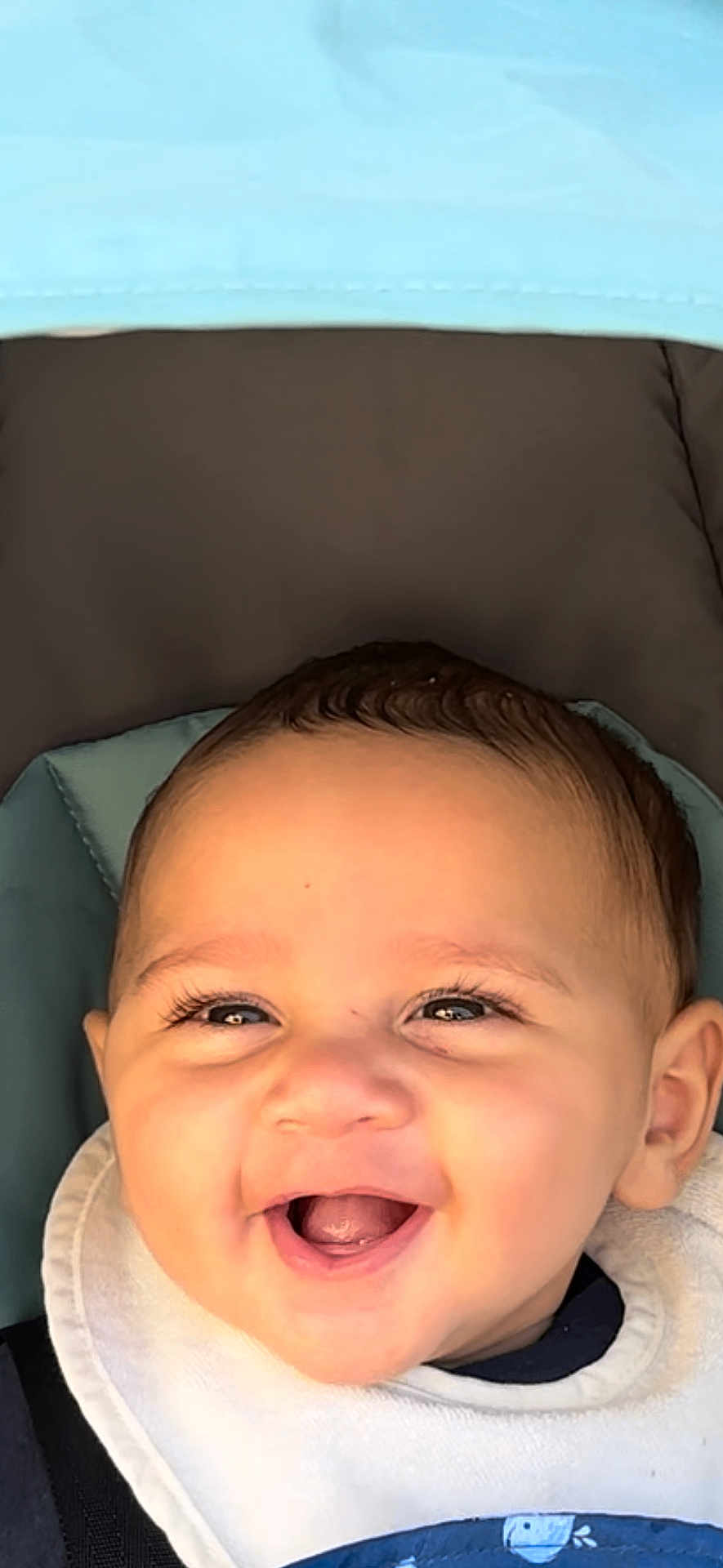 Yusif joined the competition — help win amazing prizes! baby, smile, face, child, happy, bib, stroller, infant, cute, young, portrait, closeup, eyelashes, clothing, head, skin, person, baby_bib, seat, baby_face