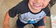 Glenn joined the competition — help win amazing prizes! child, smiling, indoor, carpet, blurry, person, young_child, toddler, shorts, tshirt, black_sock, hair, happy, face, hand, floor, blanket, home, casual, playful