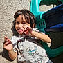child, toddler, carpet, sunlight, dinosaur_shirt, playful, smile, toy, plastic_toy, indoor, casual_clothing, short_hair, person, happy, cute, young_child, sitting, hand_gesture, face, home