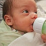 Irene joined the competition — help win amazing prizes! baby, infant, feeding, bottle, blanket, newborn, face, person, cute, sleeping_bag, mouth, hand, indoors, soft_fabric, closeup, child, skin, head, eyes, nursery