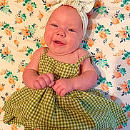 Maebrie Mahryn joined the competition — help win amazing prizes! baby, smiling, green_dress, headband, bow, floral_pattern, blanket, cute, infant, portrait, happy, child, lying_down, cheerful, skin, person, indoors, closeup, baby_girl, fashion
