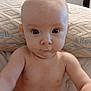 baby, infant, child, face, eyes, blue_eyes, bald_head, bare_chest, blanket, mattress, pillow, diaper, bed, indoor, portrait, close_up, sitting, curious, expression, soft_lighting
