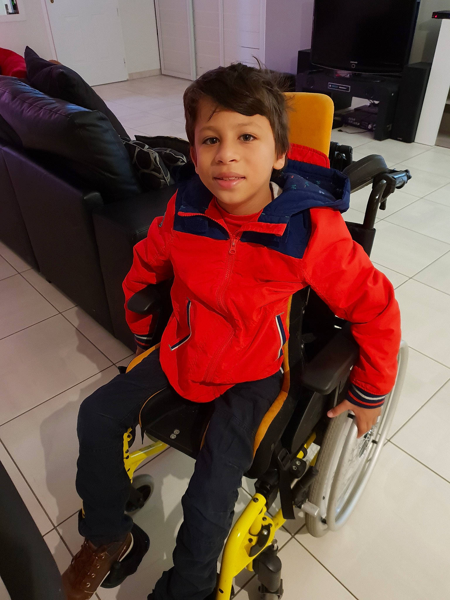 Lucas a rejoint le concours — aidez-le/la à gagner de superbes lots ! baby_carriage, baby_products, boy, child, costume, footwear, fun, outerwear, person, personal_protective_equipment, product, red, standing, wheelchair