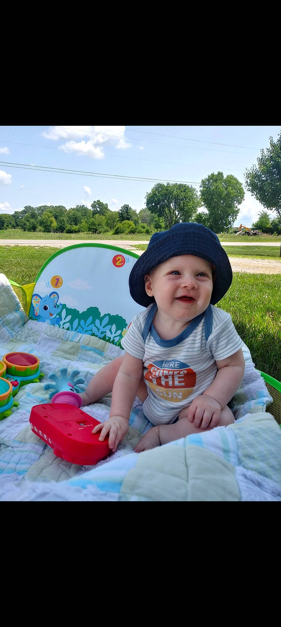 Waylon is registered to the contest to win money with this photo: baby_toddler_clothing, cap, cloud, fun, grass, happy, hat, headgear, headwear, joy, leaf, leisure, person, photograph, pink, plant, recreation, sky, smile, summer