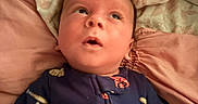 Takoa is registered to the contest to win money with this photo: baby, infant, bed, blanket, pajamas, onesie, face, hair, looking_up, hand, fabric, sleepwear, cute, child, indoors, person, skin, expression, soft, resting