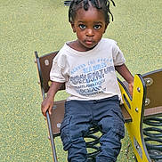 Clayton participe au concours pour gagner de l'argent avec cette photo : child, toddler, playground, spring_rider, braided_hair, graphic_tee, cargo_pants, sneakers, outdoor, play_equipment, seat, green_surface, expression, looking_at_camera, casual_clothing, young_child, daylight, park, recreation, kid