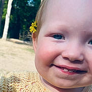 Adalynn is registered to the contest to win money with this photo: toddler, child, face, smile, flower, yellow_flower, outdoor, nature, grass, tree, blue_eyes, cheeks, baby_teeth, close_up, portrait, happy, cute, skin, head, hair