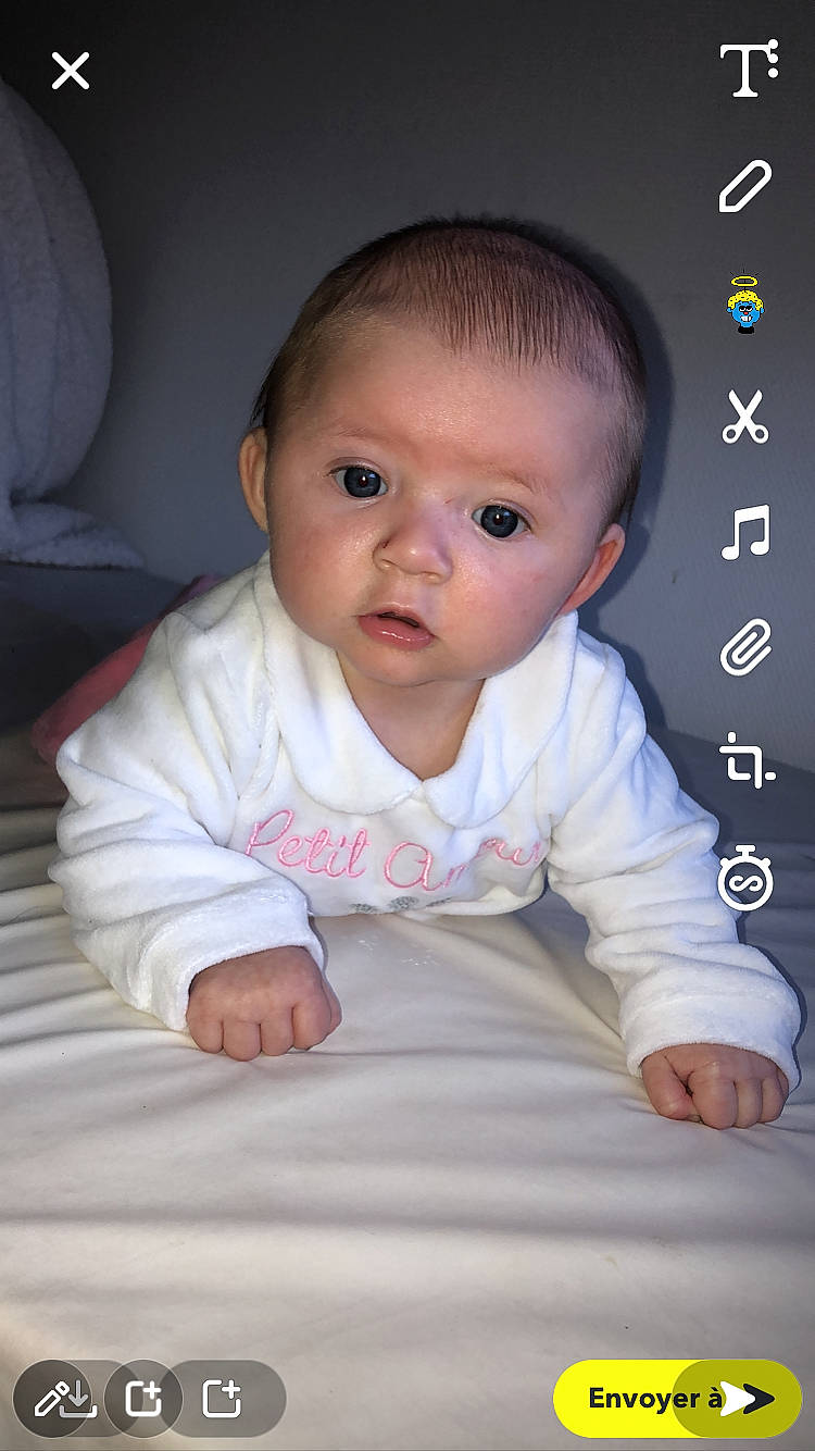 Kayla participe au concours pour gagner de l'argent avec cette photo : baby, baby_toddler_clothing, cheek, child, chin, comfort, eyebrow, eyelash, flash_photography, flooring, hardwood, iris, nose, person, sitting, skin, sleeve, smile, toddler, white