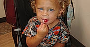 April is registered to the contest to win money with this photo: baby, blue_eyes, cabinet, child, curious, curly_hair, cute, floor, harley_davidson, indoor, lollipop, person, purse, shirt, sitting, snack, stroller, toddler, towel, wood_floor