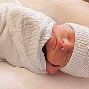 Timéo a rejoint le concours — aidez-le/la à gagner de superbes lots ! newborn, baby, sleeping, swaddled, white_blanket, knit_hat, hospital_bassinet, infant, peaceful, soft_texture, face, headwear, resting, indoors, person, closeup, portrait, hospital, newborn_care, baby_care