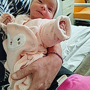 Syléa a rejoint le concours — aidez-le/la à gagner de superbes lots ! newborn, baby, infant, pink_onesie, cute, face, adult_hand, cradling, indoor, hospital_room, furniture, bed, blanket, hat, person, portrait, cozy, soft_texture, curious, child