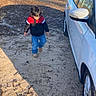 boy, car, casual_clothing, child, daylight, dirt_path, field, jacket, jeans, nature, outdoor, shadow, sky, sunny, toddler, transportation, trees, vehicle, walking, white_car