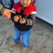 Eli is registered to the contest to win money with this photo: child, boy, jacket, red, black, blue_jeans, shoes, car, white_car, hand, seed_pods, outdoor, sand, curious, standing, person, nature, daylight, casual_clothing, young