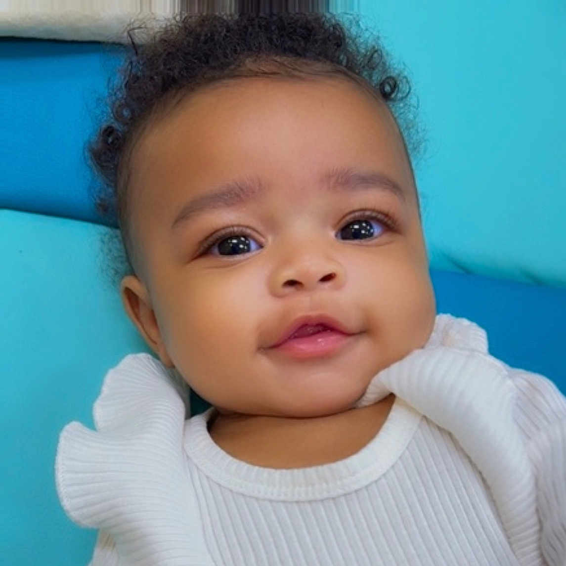 Kaliyah Blue- Rogers is registered to the contest to win money with this photo: baby, bright_eyes, child, close_up, curly_hair, cute, face, happy, head, infant, innocence, person, portrait, ruffled_sleeves, seated, skin, smile, soft_background, white_clothing, young_child