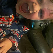 Jax is registered to the contest to win money with this photo: casual_clothing, child, couch, cozy, face, fire_truck_pattern, fun, hand, happy, headphones, home, indoor, leather, pajamas, person, playful, sitting, smiling, tongue_out, young