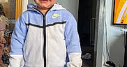 Jax joined the competition — help win amazing prizes! birthmark, blue_jeans, boy, cabinet, carpet, casual_clothing, child, curtains, doorway, framed_picture, furniture, home, indoor, nike_jacket, person, room, smiling, socks, standing, television