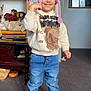 Mason is registered to the contest to win money with this photo: child, indoor, smiling, hat, pink, sweatshirt, jeans, sneakers, carpet, dolls, furniture, photograph, toys, portrait, blue_eyes, happy, person, room, casual_clothing, home