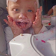 Alaiah Seddon joined the competition — help win amazing prizes! baby, child, pink_bow, high_chair, cake, frosting, messy_face, tongue_out, happy, cute, infant, feeding, celebration, smiling, face, hands, indoor, person, clothing, headband
