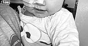 Alaiah Seddon is registered to the contest to win money with this photo: baby, cabinet, child, clothing, cute, expression, face, healthcare, holding, home, indoor, looking_down, medical, monochrome, nasal_tube, person, person_holding, portrait, shirt, sleeve