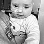 baby, child, face, person, indoor, monochrome, nasal_tube, medical, clothing, holding, cute, portrait, expression, looking_down, sleeve, shirt, cabinet, home, person_holding, healthcare