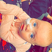Alaiah Seddon joined the competition — help win amazing prizes! adult, baby, blanket, blue_eyes, carpet, child, closeup, curious, floor, footwear, furniture, hand, healthcare, indoor, nasal_tube, person, pink_clothing, room, sleeve, toy