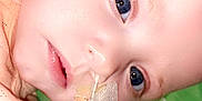 Alaiah Seddon is registered to the contest to win money with this photo: baby, infant, face, blue_eyes, nasal_tube, medical_tape, close_up, lying_down, peach_clothing, child, person, skin, head, expression, healthy, young, cute, indoors, colorful_background, soft_lighting