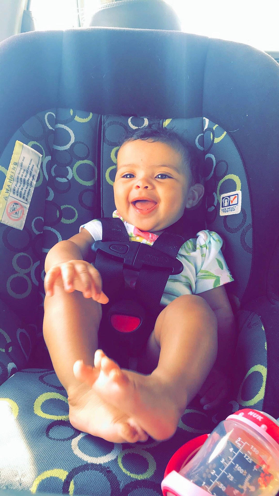 Braylynn is registered to the contest to win money with this photo: arm, baby, car_seat, cheek, child, facial_expression, fun, hand, happy, leisure, person, photography, play, product, sitting, skin, smile, toddler, vacation