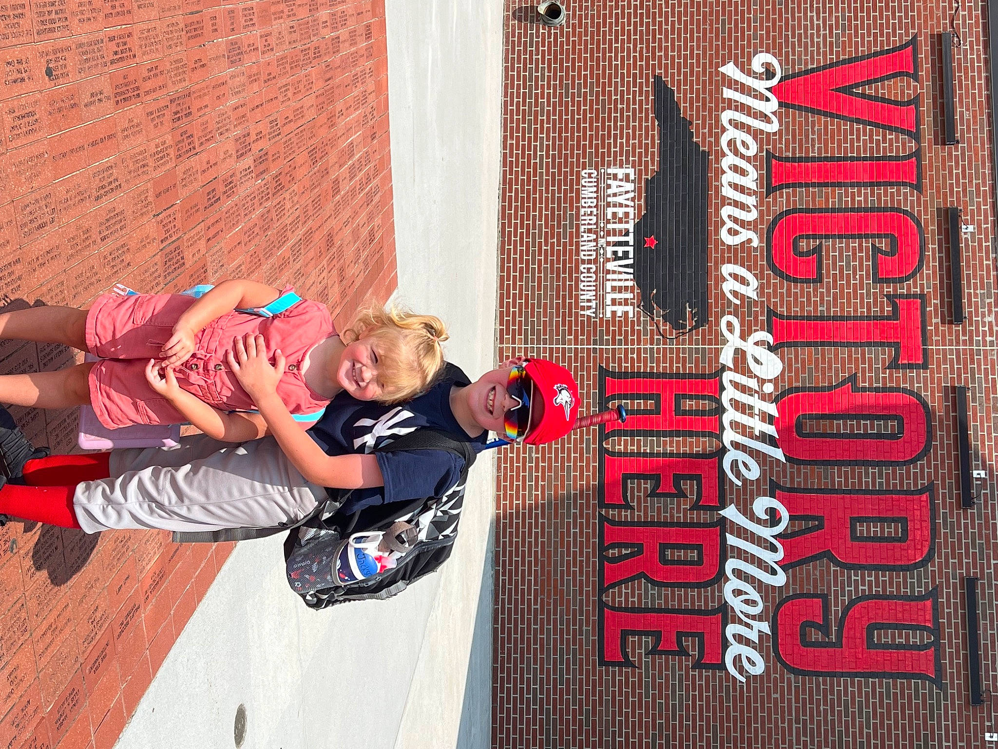 Olivia is registered to the contest to win money with this photo: advertising, art, brick, brickwork, facade, flooring, font, fun, headwear, joy, leisure, outdoor_shoe, pattern, person, recreation, rolling, shorts, skateboarder, sports, sports_equipment