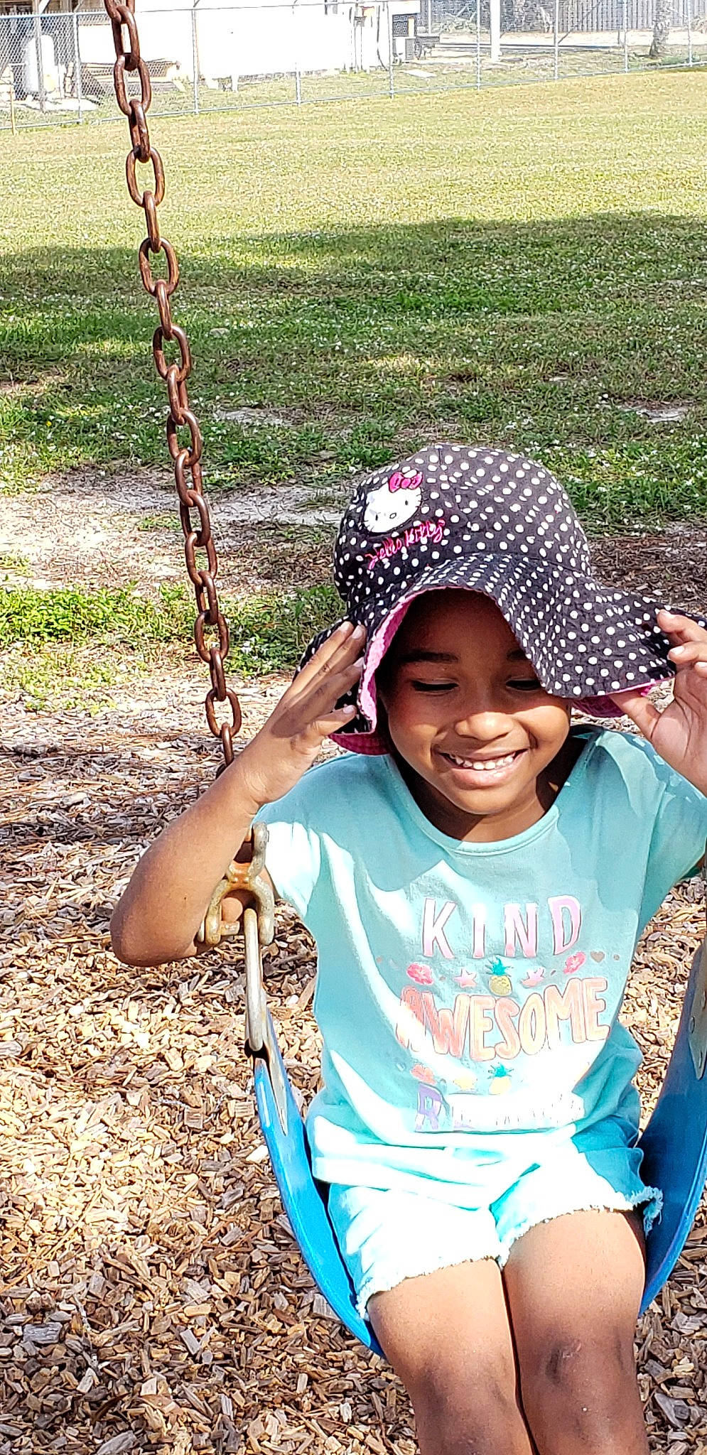 Anya is registered to the contest to win money with this photo: child, fun, grass, happy, headgear, headwear, joy, outdoor_play_equipment, person, plant, play, smile, summer, swing, toddler, tree
