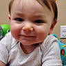Cannon is registered to the contest to win money with this photo: baby, child, infant, smile, face, arm, clothing, indoor, toy, seat, colorful, pattern, person, cute, young, happy, skin, hair, expression, playful
