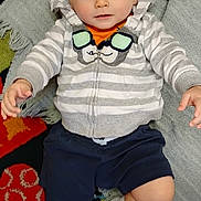 Cannon is registered to the contest to win money with this photo: baby, child, striped_hoodie, bowtie, navy_shorts, white_socks, blanket, colorful_rug, indoor, cute, curious, seated, young_child, portrait, soft_lighting, casual_clothing, floor, comfort, happy, infant