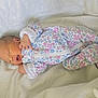 newborn, baby, infant, onesie, floral_pattern, sleeping, blanket, soft, cute, small_hands, face, lying_down, indoors, peaceful, child, portrait, sleepwear, cozy, resting, new_life