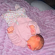 Alana is registered to the contest to win money with this photo: newborn, baby, infant, pink_clothing, floral_pattern, blanket, purple_blanket, sleeping, yawning, fist, soft_texture, cozy, cute, small, bed, resting, indoors, portrait, child, person