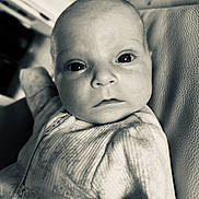 Florrie is registered to the contest to win money with this photo: baby, infant, face, eyes, onesie, patterned_clothing, closeup, portrait, skin, head, expression, curious, black_and_white, texture, fabric, newborn, child, person, indoor, soft_light